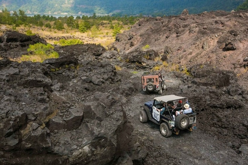 4x4 jeep driving through Mount Batur’s volcanic terrain during sunrise jeep adventure.