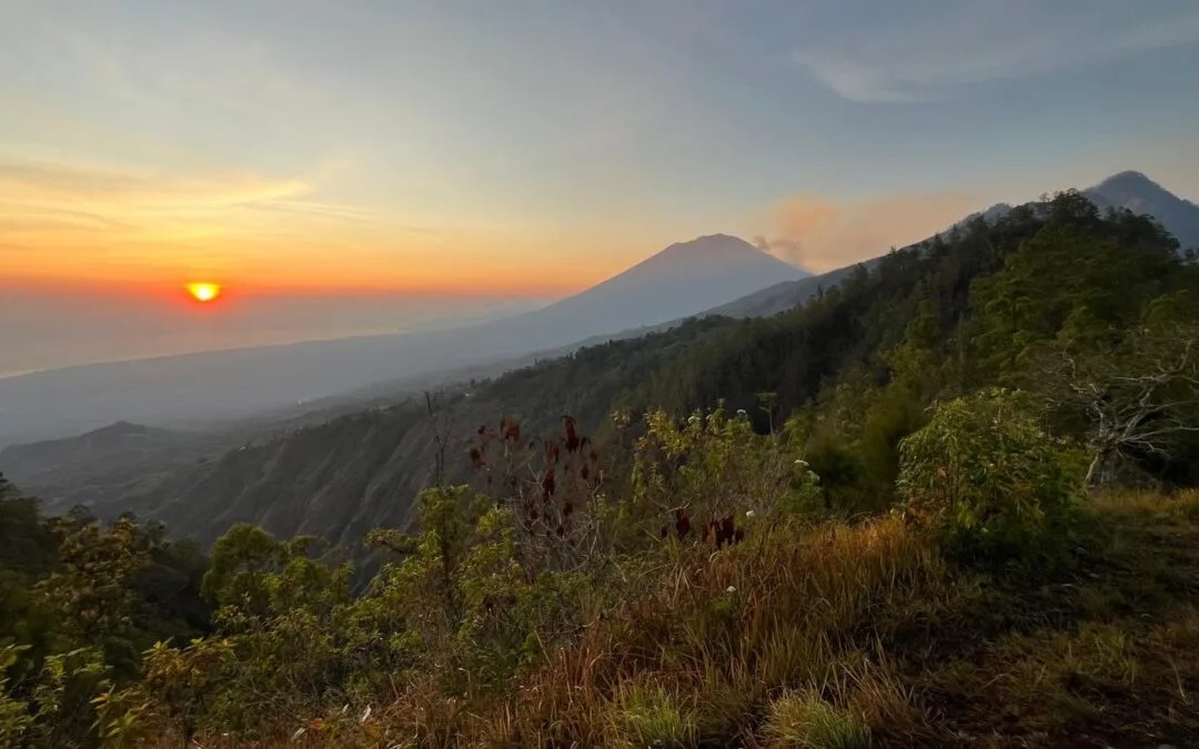 Mount Batur sunrise viewed from the summit with warm golden light.